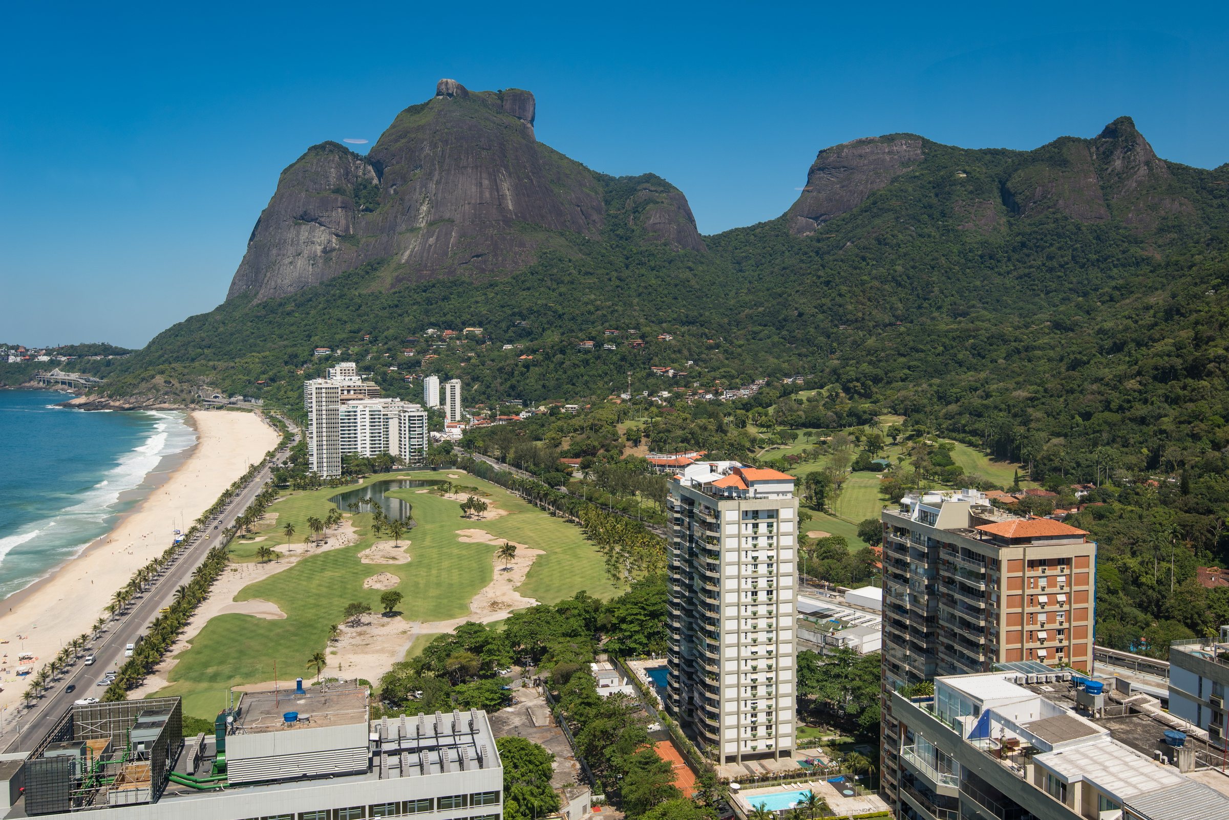The Atlantic Forest spilling down the flanks of Pedra da Gávea toward the coast.